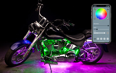 Motorcycle glowing with LED accent lighting beside a smartphone color control app